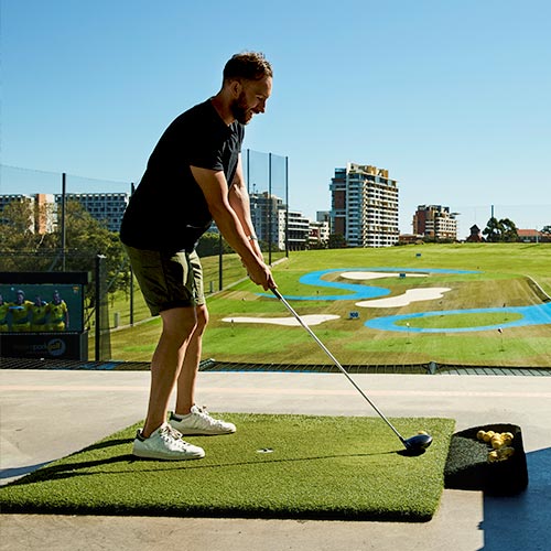 Man golfing at driving range