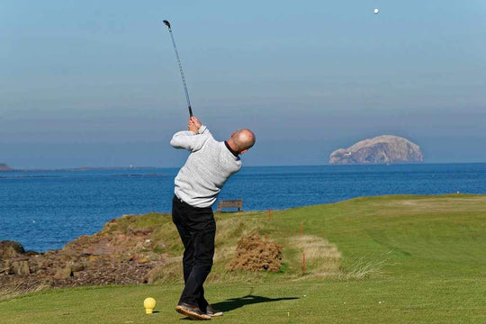 man hitting golf ball and hitting a slice