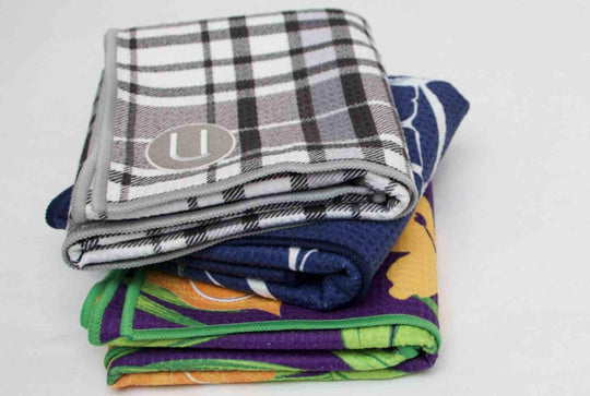 Uther plaid swordfish and flower golf towels stacked on-top of one another